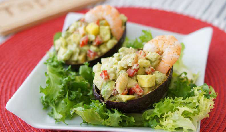 Avocados stuffed with prawns and fruit salad with tartar sauce